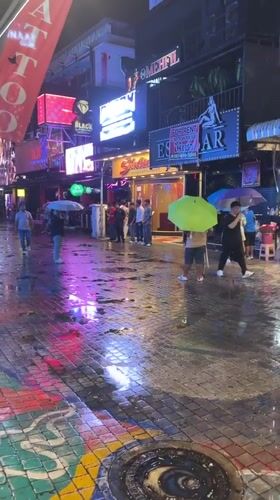 Rainy night street activity continues in Pattaya commercial district