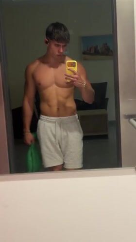 Locker room mirror selfie in Sofia, grey sweatpants and earbuds