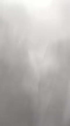 The video shows a close-up of a scary Halloween decoration. It is a white skull face with a black veil draped over it. The skull has cracks on its forehead and dark eye sockets. It is set against a textured wall that appears to be white or light gray. A creepy, growling sound accompanies the visual.
