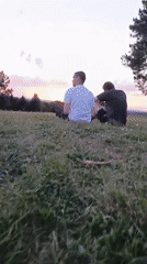 Two men watch sunset on hilltop near Chuma, Russia