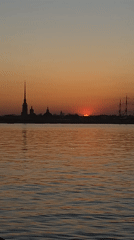 Angler fishes at Sankt-Peterburg riverfront during colorful sunset