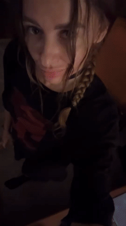 Woman adjusts hair while looking at camera in Mengwi