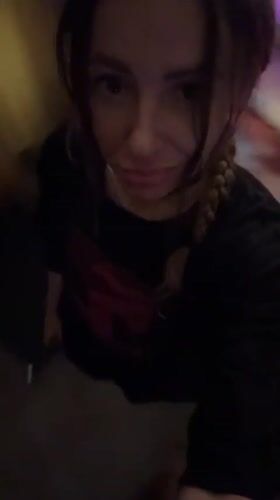 Woman adjusts hair while looking at camera in Mengwi