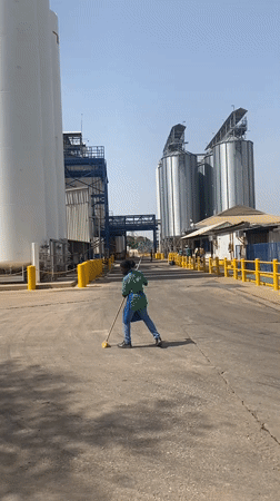 Worker sweeps industrial facility grounds in Nassarawa, Nigeria