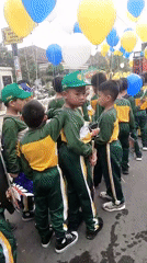 Festive street parade with balloons and uniforms in Ambulu, Indonesia