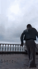 Girl plays with dog on Sochi balcony overlooking sea