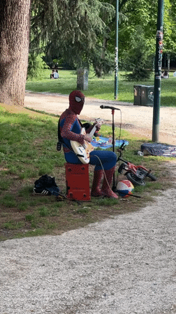Spider-Man street performer plays guitar in Milan park