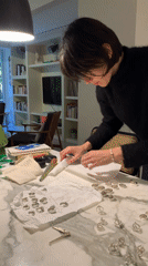 Person organizes silver rings at marble counter in Buenos Aires