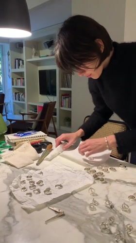 Person organizes silver rings at marble counter in Buenos Aires