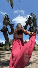Tourist documents traditional Balinese sculptures in Kedewatan garden setting