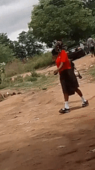 Pedestrians spotted on rural dirt road near parked vehicles