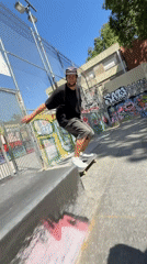 Skateboarder practices tricks at Barcelona park on sunny afternoon