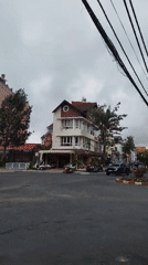 Da Lat street corner: colonial buildings, vendors, and morning overcast