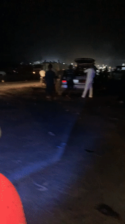 Motorcycle navigates crowded nighttime gathering in Lokoja, Nigeria