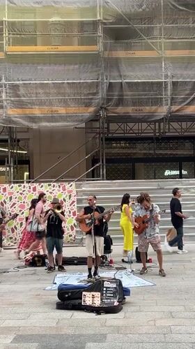Live street band plays outside a construction site in Barcelona
