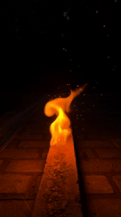 Flammable substance burns on brick pavement at night