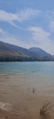 Beach day: swimming, jet skiing, mountain backdrop