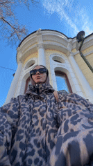 Woman documents historic architecture during early morning walk in Krasnoyarsk