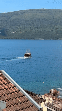 Small boat with flags spotted in waters near Bijela, Montenegro