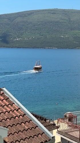 Small boat with flags spotted in waters near Bijela, Montenegro