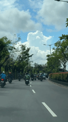Scooter convoy travels road in Kuta Selatan, Indonesia