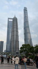 Tourist crowds photograph Shanghai skyline in Pudong district