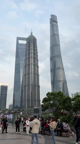 Tourist crowds photograph Shanghai skyline in Pudong district