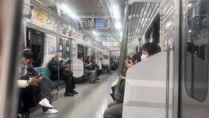 Masked passengers observed on Shinjuku train using mobile devices