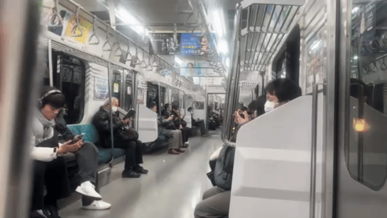 Masked passengers observed on Shinjuku train using mobile devices