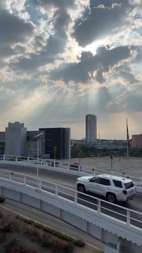 Dramatic sunbeams pierce storm clouds over Puebla cityscape