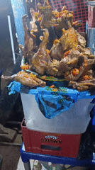 Street vendor sells cooked poultry at Ozalla market