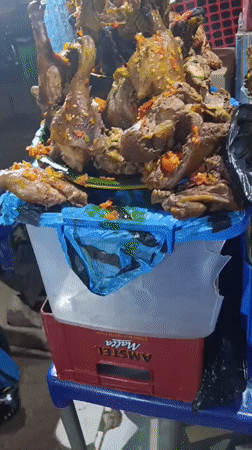 Street vendor sells cooked poultry at Ozalla market