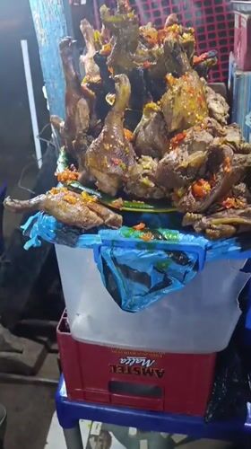 Street vendor sells cooked poultry at Ozalla market