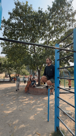 Man performs morning calisthenics workout on Kathmandu playground equipment