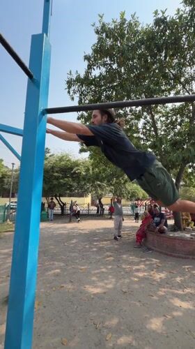 Man performs morning calisthenics workout on Kathmandu playground equipment