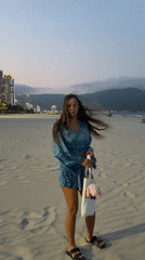Woman walks beach at dusk in Đà Nẵng