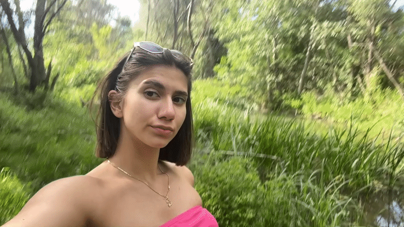 Woman films selfies near wooded pond in Sofia