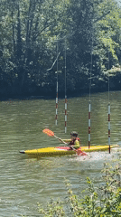 Kayakers navigate tree-lined river in Longeville-lès-Metz on sunny afternoon