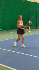 Woman practices tennis indoors Saturday morning
