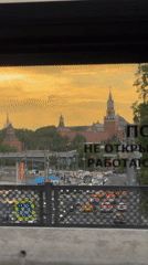 Moscow Kremlin silhouetted at sunset amid busy traffic