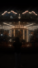 Lone observer watches empty carousel spin in nighttime Florence