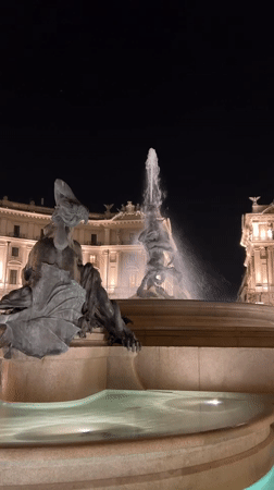 Baroque fountains and basilica lit up in central Rome