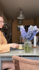 Woman enjoys morning breakfast with dog in Khimki kitchen