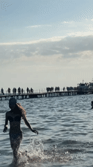 Beach volleyball and pier crowds on a summer day in Anapa