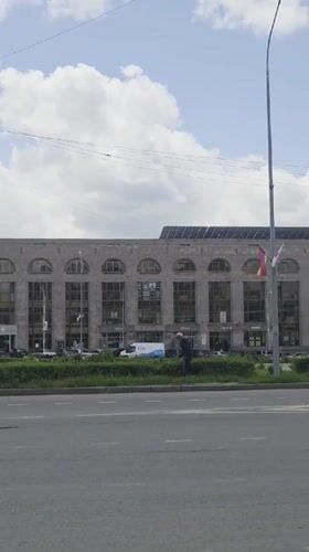 Morning street activity captured near historic stone building in Gyumri