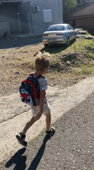 Child with Spider-Man backpack walks Podgorica road early morning