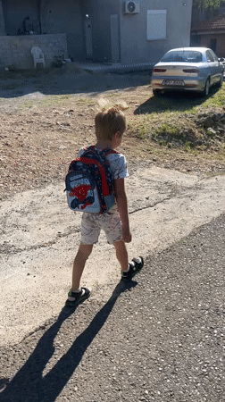Child with Spider-Man backpack walks Podgorica road early morning