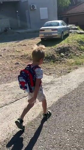 Child with Spider-Man backpack walks Podgorica road early morning