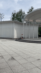 Child rides bikes, toy car near colonnade plaza