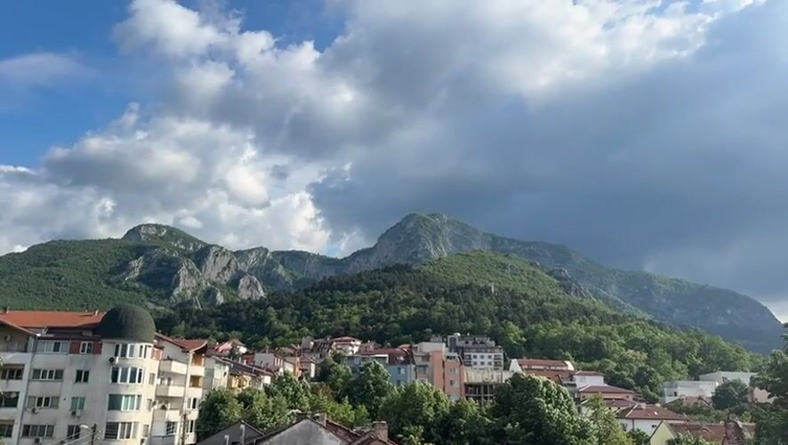 Town of Vratsa captured beneath mountains on cloudy afternoon